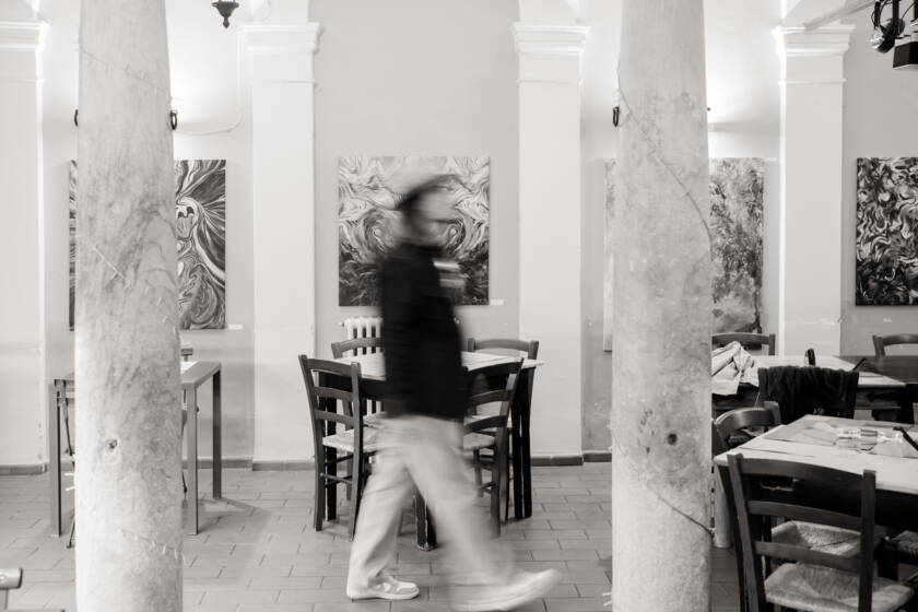 Alessio Bonini attraversa la sala durante l'allestimento della sua mostra personale Zatra a Sarzana